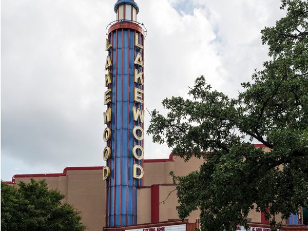 The tall blue Lakewood sign tower above the Lakewood Theater on a cloudy day